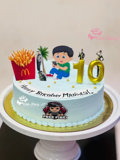 A cake for the ultimate gamer. This Free Fire theme cake includes a character busy on his phone, along with french fries and other game elements for a 10th birthday.
