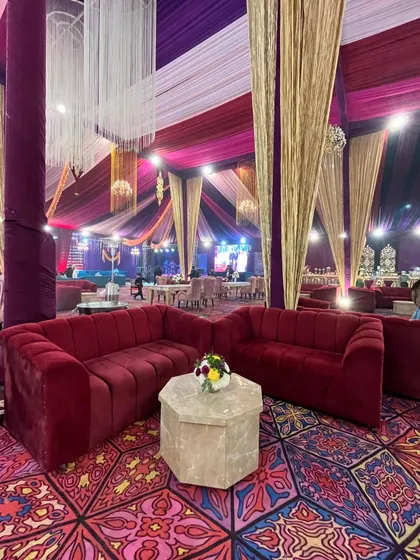 A cozy lounge nook with plush red sofas, perfect for intimate conversations amidst the grandeur of the main event.