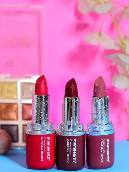 A styled scene featuring three Mamaearth lipsticks alongside a makeup palette and brush, creating a complete beauty story.