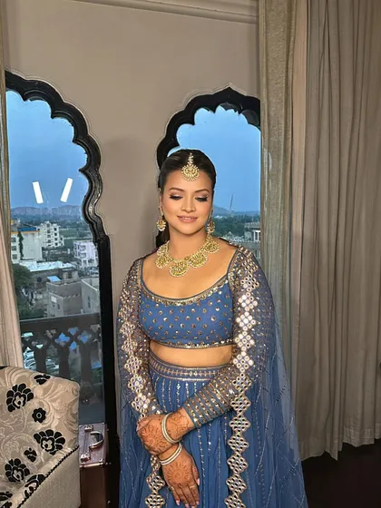 The client looks stunning in her blue lehenga, and the braided ponytail is the perfect hairstyle to complete her look.