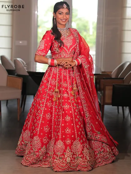 Feel like a classic bride in this radiant red lehenga. The detailed silver embroidery and perfect flare make it a timeless choice for your wedding day.