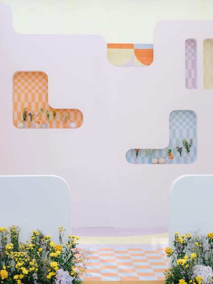 Detail of the checkered and pastel-colored niches in a wall, filled with minimalist floral arrangements, part of our spring-themed summer event.