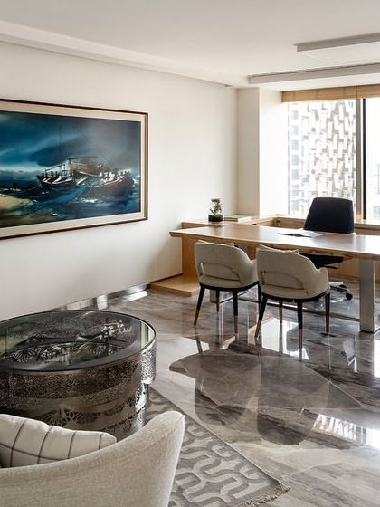 A director's cabin in the Stainless Steel Office, featuring a stunning grey marble floor that reflects the natural light. The space combines a work area with a comfortable lounge, all designed to reflect the director's personal style.