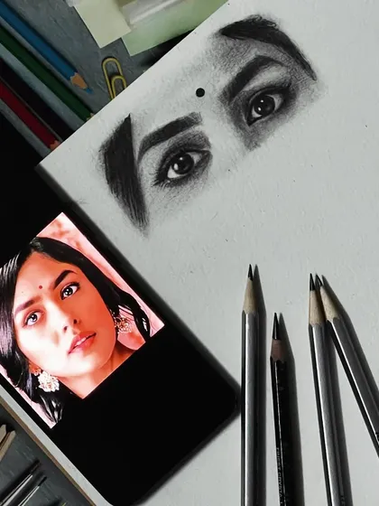Here you can see my reference photo next to the finished sketch of the eyes. Capturing the likeness, especially in the eyes, is the most important part of creating a realistic portrait.