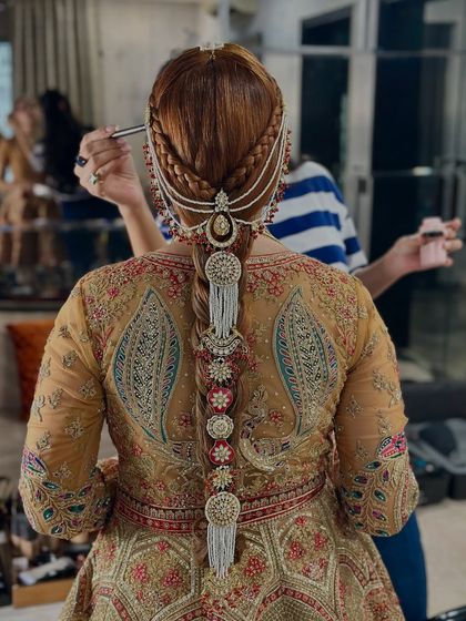 A closer look at the traditional wedding braid, focusing on the intricate pearl matha patti and side accessories.