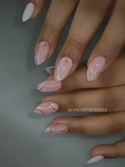 A lovely pink and white marble design with delicate gold glitter lines on almond-shaped nails.