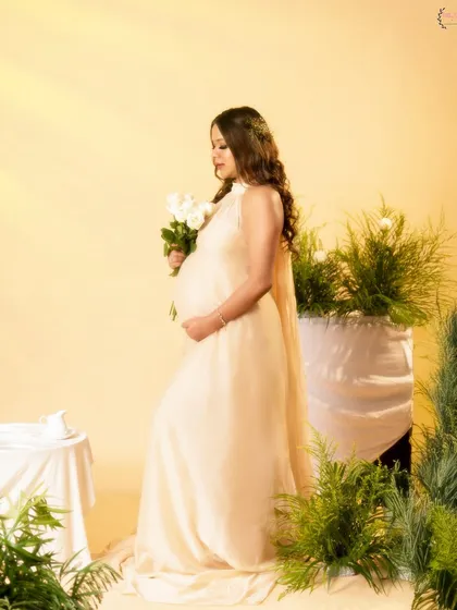 A side profile from the same dreamy, light-filled set, showcasing the beautiful silhouette of the baby bump.
