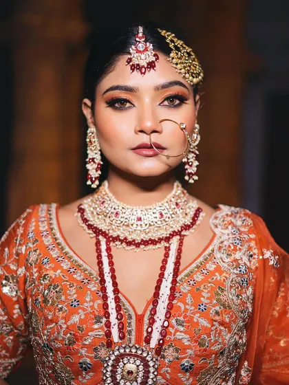 A regal portrait of the Nikkah bride. The makeup is designed to enhance her features and complement the heavy, traditional jewelry without being overpowering.
