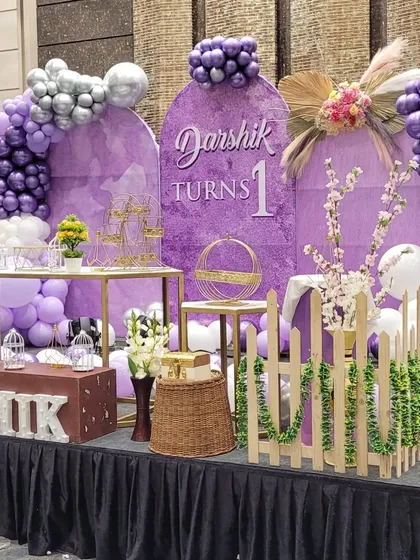 Another angle of the first birthday setup, showcasing the arrangement of dessert stands, decorative props like birdcages, and the personalized name display.