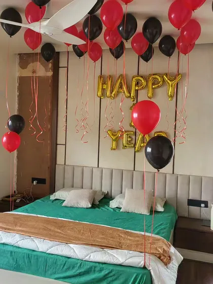 A 'Happy New Year' room decoration with red and black helium balloons and foil letters.