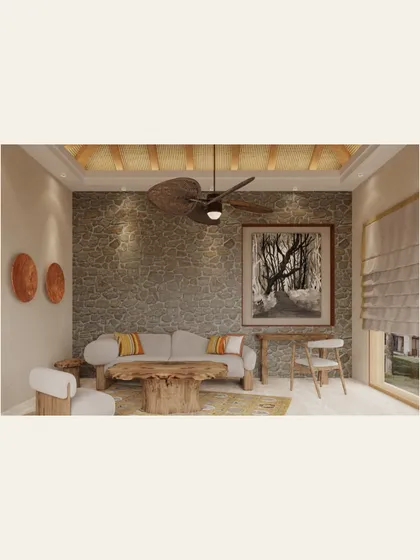 The living area of a villa in Kanha, designed as a comfortable retreat after a day in the wild. We used natural materials like a stone accent wall, a raw wood coffee table, and a woven ceiling fan to bring the textures of the surrounding forest indoors.