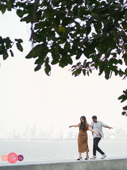 A playful moment of finding balance together, with the expansive sea and city behind them. A perfect metaphor for partnership.
