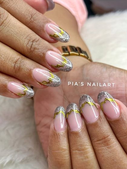 A delicate design featuring a silver glitter French tip with fine gold chrome detailing over top.