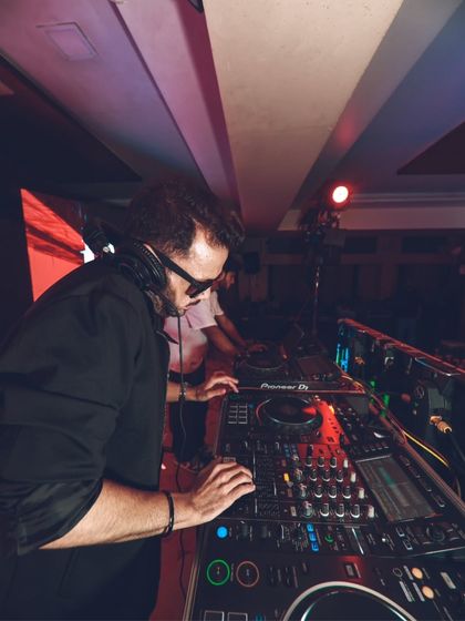 Focused on the mix at my Pioneer DJ setup. I use professional-grade equipment to ensure the sound quality and transitions are flawless for every performance.