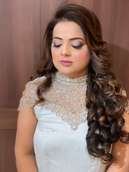 A close-up of the party makeup, featuring shimmery eyeshadow and a soft pink lip, perfectly complementing her elegant hairstyle.