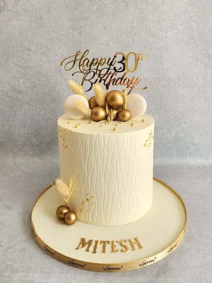 A classic white and gold cake for a 30th birthday. The textured white buttercream and simple gold accents create a modern and elegant look.