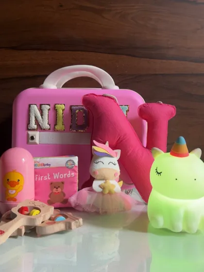 I absolutely love creating gifts for little ones. This personalized hamper for a one-year-old is filled with age-appropriate toys, a custom name suitcase, a soft unicorn plushie, and a gentle night light to make their day magical.
