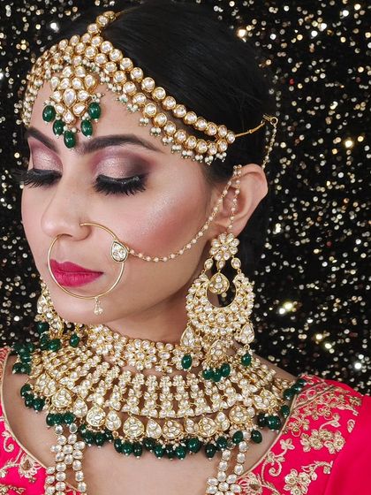 A heavy bridal set with a wide choker and layered green beads. The matching oversized chandbali earrings complete this stunning look.