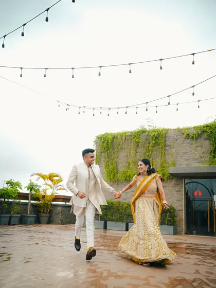 A dynamic and joyful shot of an engaged couple running hand in hand on a rooftop, capturing their excitement and happiness.