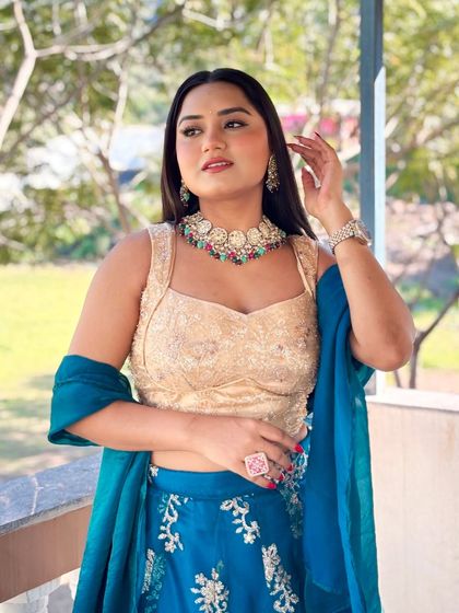 A candid moment captured during a daytime event. This blue and gold lehenga is perfect for a sunny Mehendi or Haldi, with its bright colors and comfortable style.