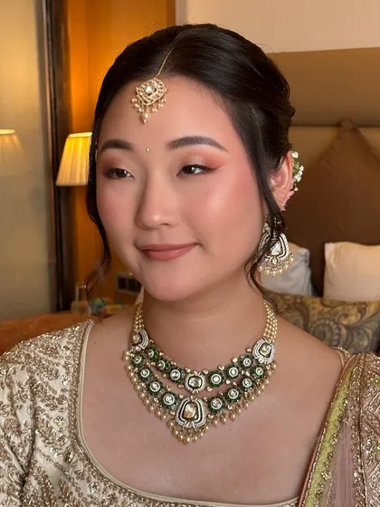 I believe in enhancing, not transforming. For this beautiful bride, I used soft pink and peach tones on the eyes and cheeks to complement her East Asian features and ivory lehenga, creating a fresh and radiant pre-wedding look.