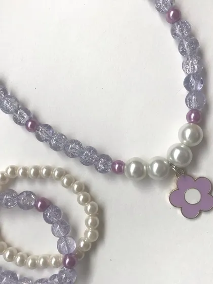 A clean, simple shot of the purple flower charm necklace and bracelet set. The combination of crackle beads and pearls gives it a lovely texture.