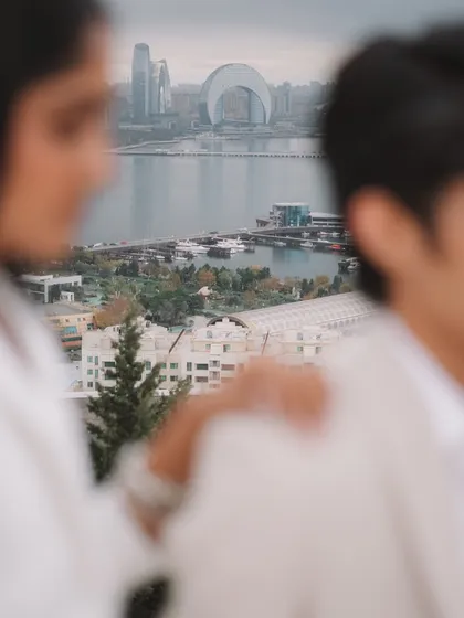Another creative use of focus, this time with the Baku cityscape and waterfront visible between the couple. It creates a sense of a shared world, a private moment with a grand view.