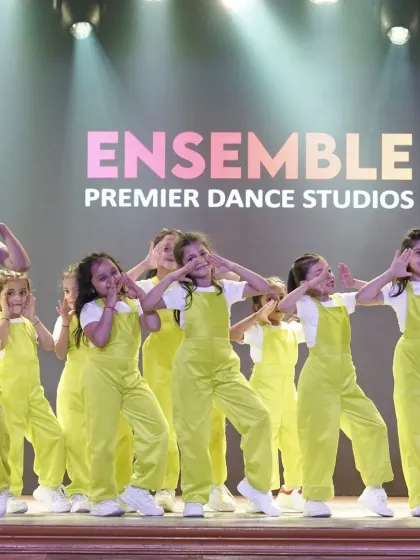 Look at those happy faces. Our students shine on stage, performing a synchronized routine in their bright neon outfits, showcasing the confidence and teamwork they've built in our classes.