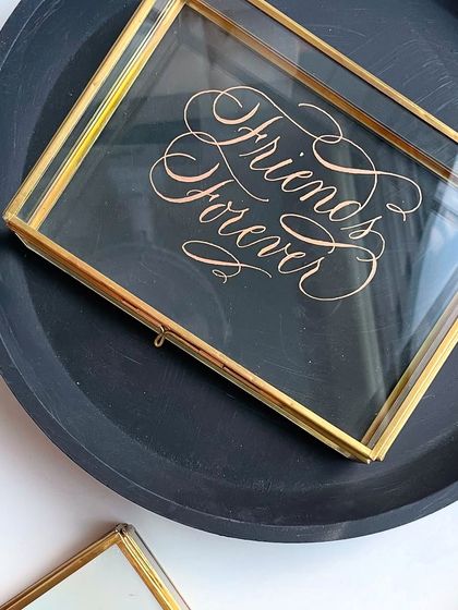 A single engraved glass box, styled simply to highlight the beauty of the calligraphy and the craftsmanship of the box itself.