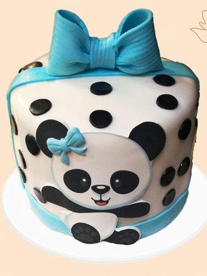 A cute and cuddly panda cake with a big blue bow. The polka dot design and adorable panda face make this a heartwarming choice for a birthday celebration.