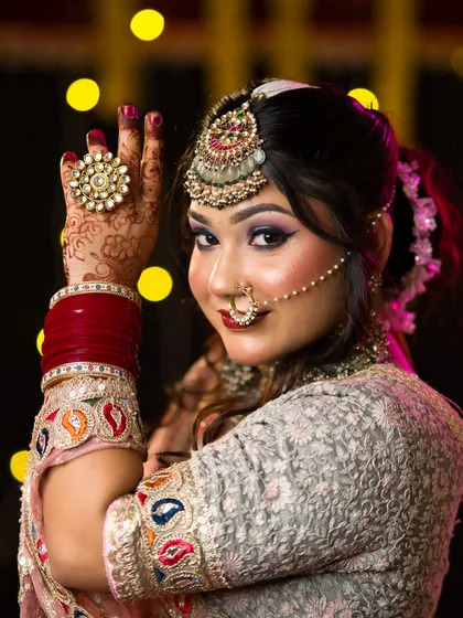 A close-up of the festive bridal look, highlighting the intricate maang tikka and the student's skill in blending bold eyeshadow colors.