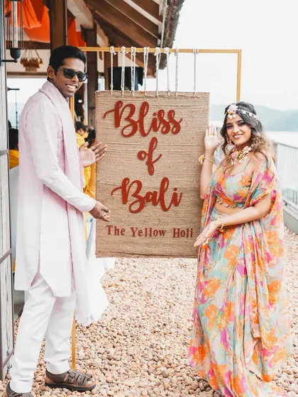 The happy couple welcoming guests to their "Bliss of Bali" themed Haldi. We love creating personalized themes that reflect the couple's personality and dreams for their wedding celebrations.