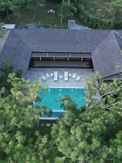 An aerial view of 'The Leaf' in Poomala, Kerala, a hospitality project nestled in dense greenery. The structure was designed to sit lightly on the land, overlooking a reservoir with minimal disturbance to the natural terrain. This project showcases our commitment to creating architecture that respects and harmonizes with its environment.