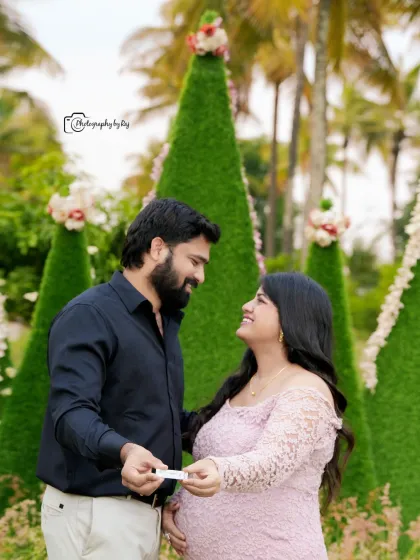 A sweet couple's portrait with a pregnancy test prop, set against our unique cone-shaped green props.