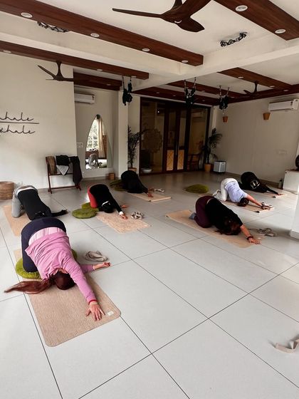 Students rest in child's pose, a moment of grounding and surrender during class.
