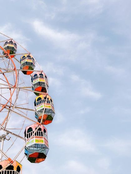 A colorful Ferris wheel is framed against a bright blue sky at a local mela. I love finding these simple, graphic compositions that evoke a sense of fun and nostalgia.