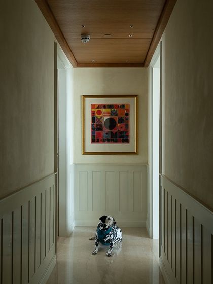 Another view of the art-filled hallway, proving that transitional spaces should never be boring. The combination of classic wainscoting and modern art creates a timeless and sophisticated look.