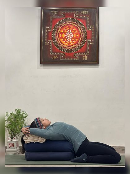 "Feel the inner mind touching your entire body, even the remotest parts." This supported Supta Virasana (Reclining Hero Pose) allows for deep rest and introspection, helping you connect with the subtle sensations within.