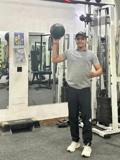 Holding the medicine ball up to show its weight. We use various weights to suit different fitness levels.