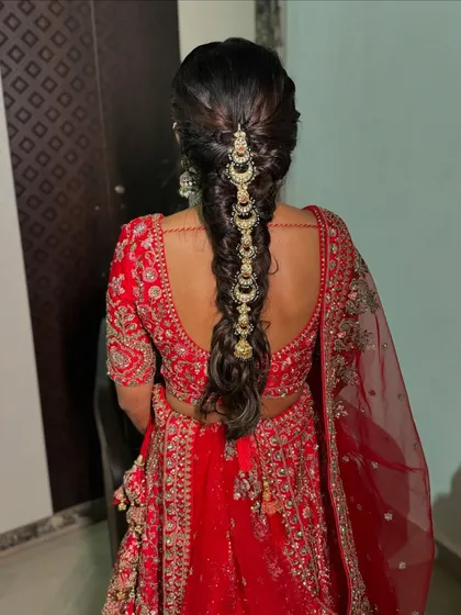 A classic bridal braid, adorned with a delicate chain of moon-shaped accessories.