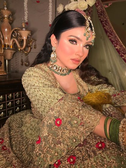 A regal pose in a beautiful olive green and maroon anarkali. The makeup is kept classic with a defined eye and neutral lip to let the outfit's rich colors shine.