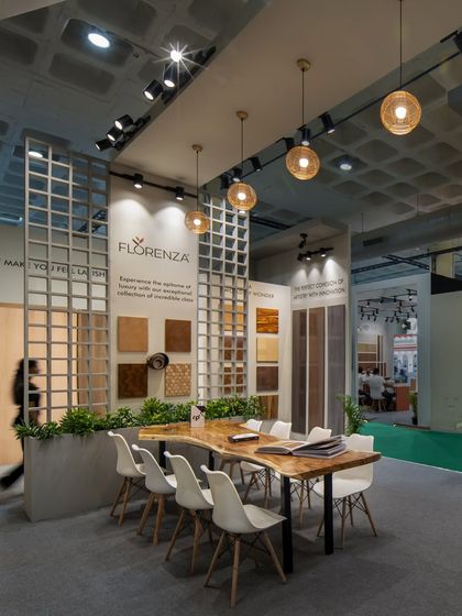 Inside the RP Plywood stall, a live-edge wooden table provides a natural contrast to the modern, geometric trellis wall. This area was designed for detailed discussions and reviewing product catalogues.