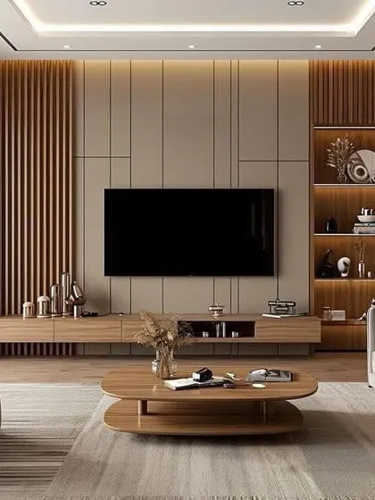 A wide view of a living room with a full-wall TV unit made of wood and fluted panels. The design incorporates both open and closed storage, with warm backlighting to highlight the decorative shelving.