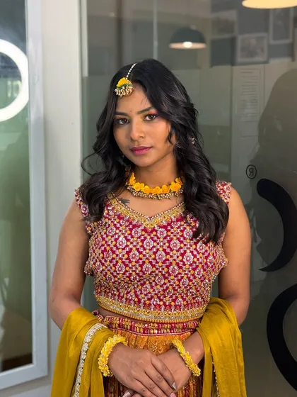 A portrait of the beautiful Haldi makeup look. The soft waves and floral jewelry complement the fresh and glowing makeup perfectly.