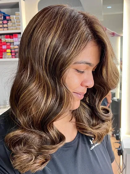 A close-up of the beige blonde balayage, showing the seamless blend and soft, wavy styling.