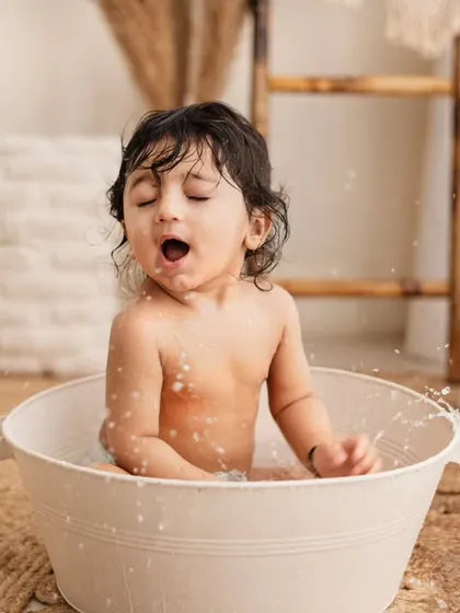A funny face during his birthday tub splash! These candid moments of pure fun and surprise are what make splash sessions so memorable.
