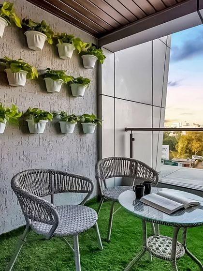 We created a simple yet beautiful balcony garden using wall-mounted planters and artificial grass. This low-maintenance setup provides a green view and a cozy seating area.