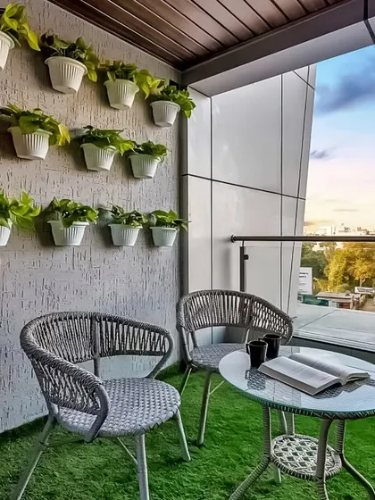 A simple yet effective balcony decor idea. This design uses a wall-mounted grid of planters to create a vertical garden, paired with comfortable seating, turning a small space into a green and pleasant nook.