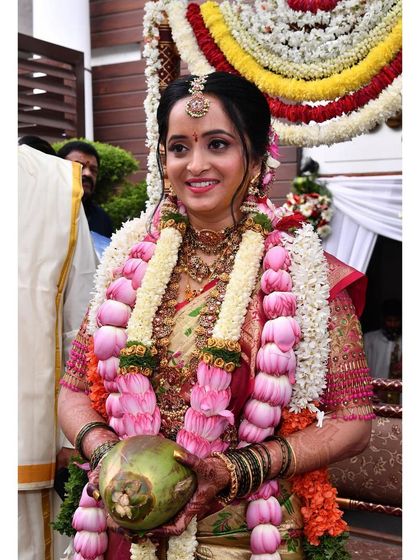 A happy moment during the Gouri Pooja. The makeup is kept fresh and traditional, with a smile that lights up the room.