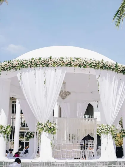 A stunning all-white wedding mandap, showcasing the elegant and grand decor created by our partner, Behind The Scenes.